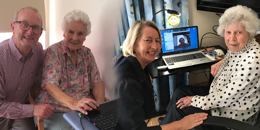 mature man and older mother using laptop younger and older women in front of computer