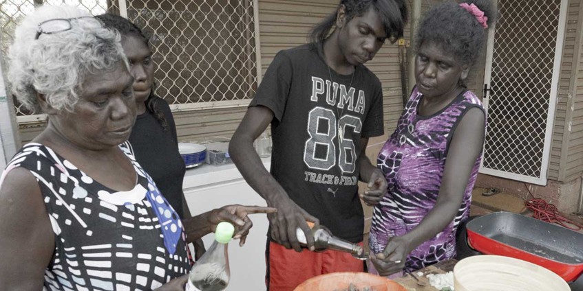 Three women and yound man cooking