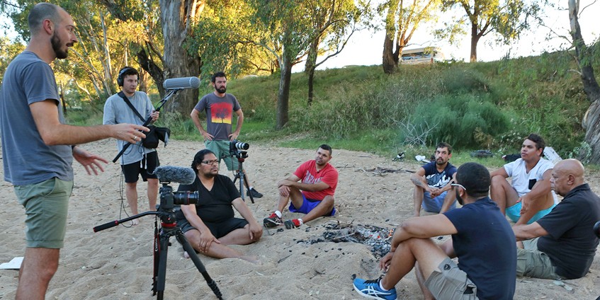 group of men sitting and talking to video producers