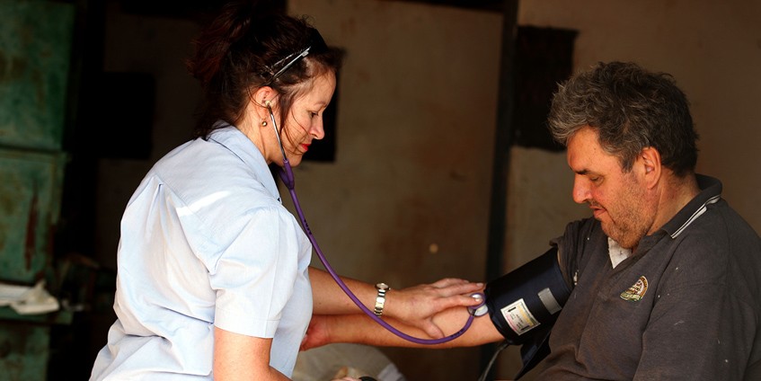 Nurse checking mans pulse