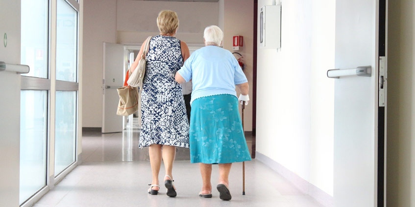 Elderly woman with younger woman in medical facility