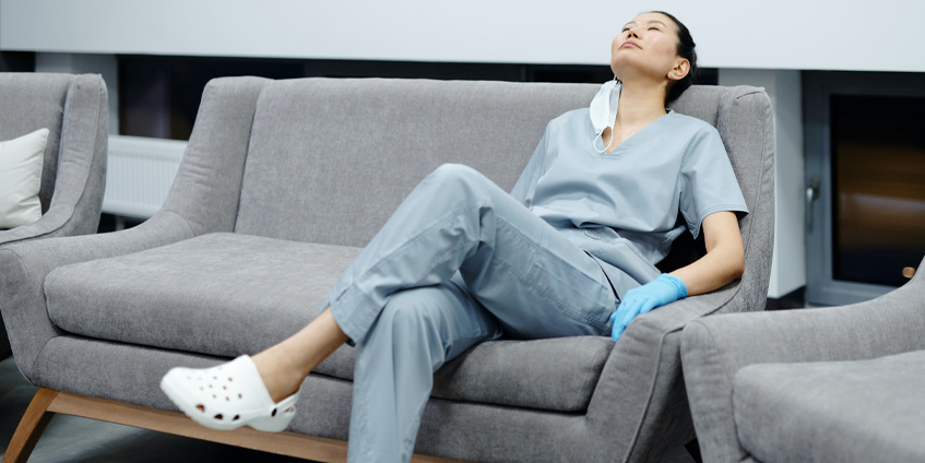 Woman resting on lounge wearing mask