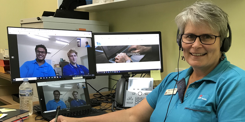 Ellen McMaster in front of computer monitors