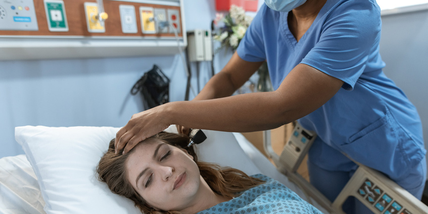 Nurse checking female patients temperature