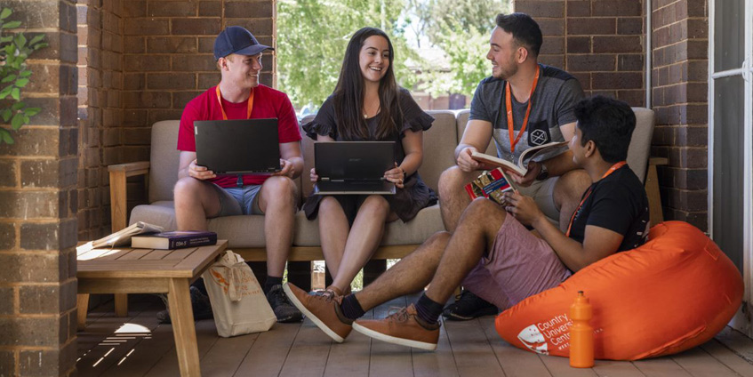 Students with laptops sitting together