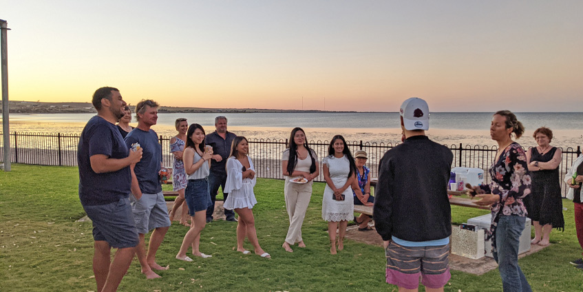 Group of people and students at a gathering by the sea