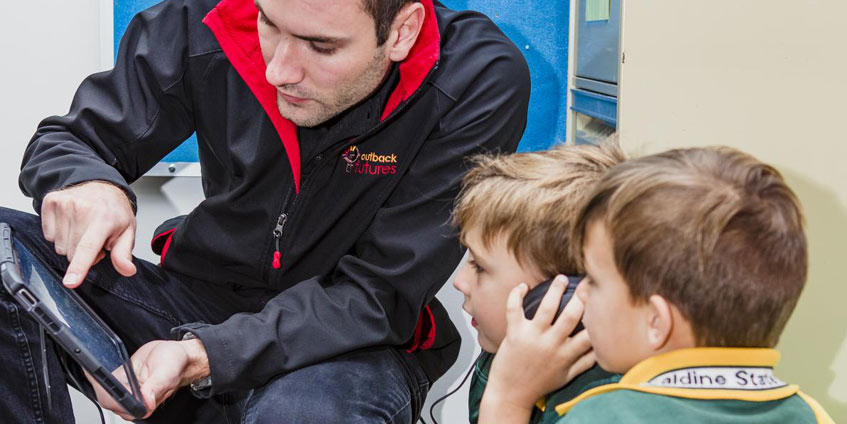 An Outback Futures staff member explaining the Rumble’s Quest tool to school children.