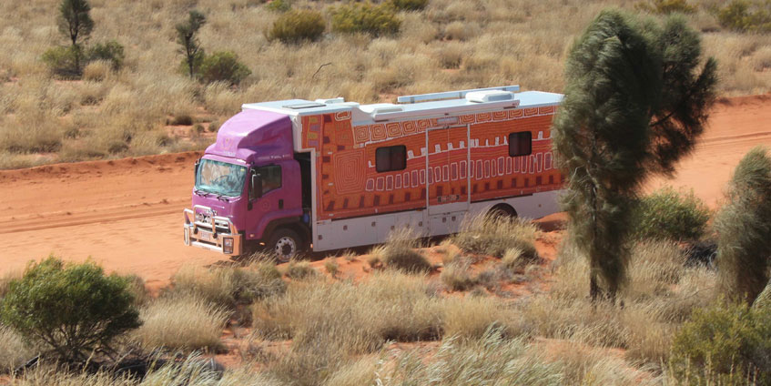 Purple truck on a red dirt track