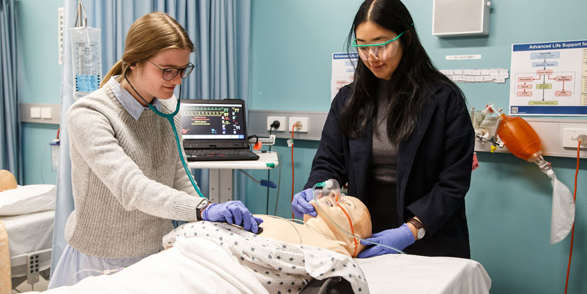 Two medical students with training dummy