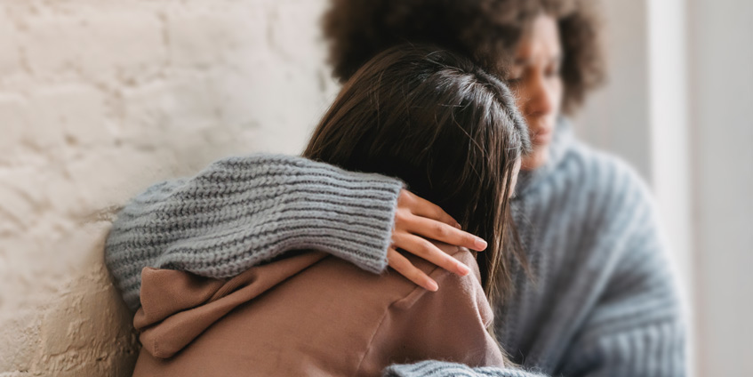 Woman hugging another woman