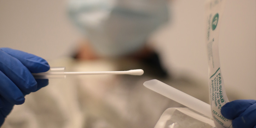 Medical person with cotton tip swab