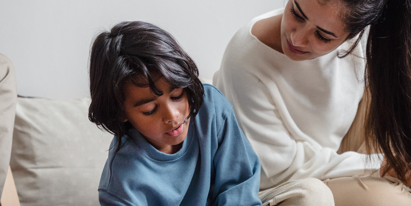 Mother helping son who is drawing