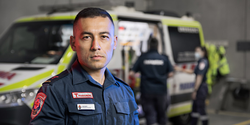Male paramedic in front of ambulance