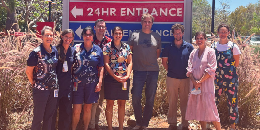 Group of people in front of hospital entrance sign
