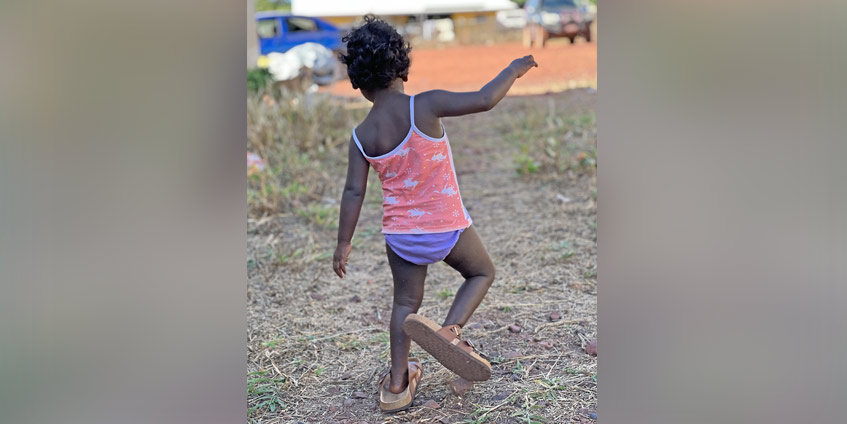 Young child wearing adult shoes