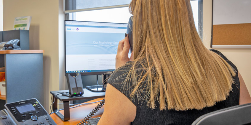 Woman using phone seated at an office desk