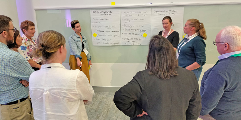 Group of people at the session discussing topics on a white board