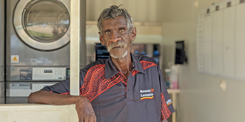 Frederick ‘Freddie’ Scrubby, who works at the Barunga laundry. Standing in front of laundry machines.