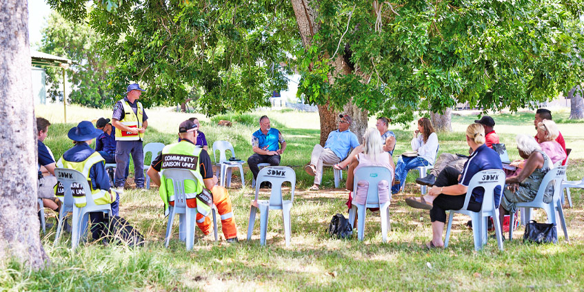 Group of people seated outdoors in a circle talking