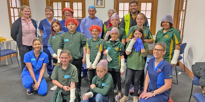 Group of children with arm casts and nurses