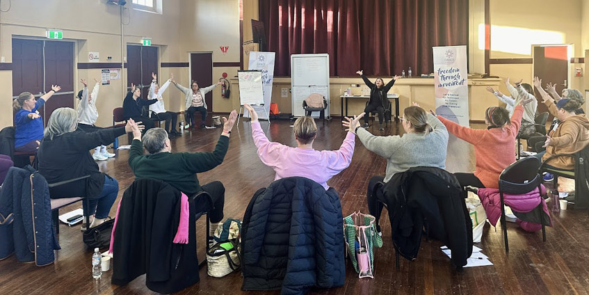 People seated in a community hall having a dance session