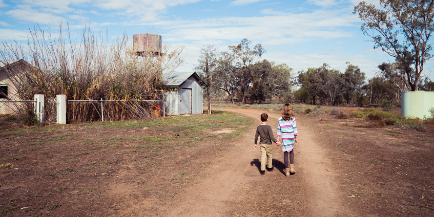 Young boy and girl walking on a rural property