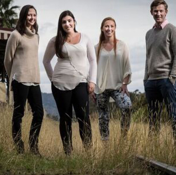 Four young adults standing on railway line