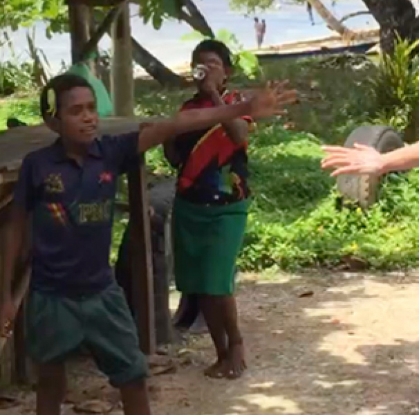 Local PNG boy high fiving push bike rider.