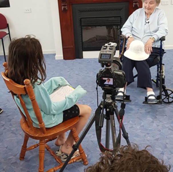 Young girl interviewing elderly woman