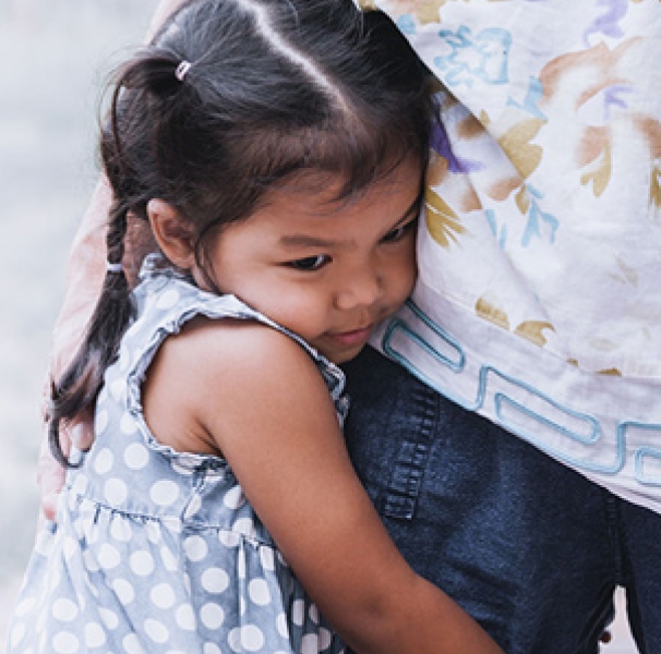 Girl hugging adult