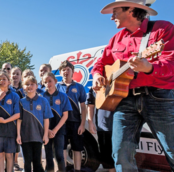 Josh Arnold and primary school kids in front of the Grand Chancellor