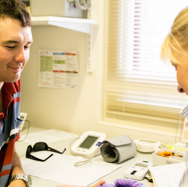 Young man getting his blood tested by female nurse