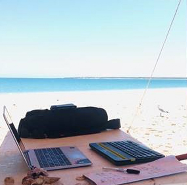 Laptop on camp table on the beach