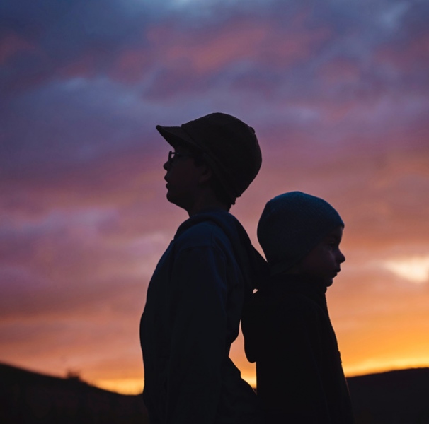 Two boys silhouetted against sunset
