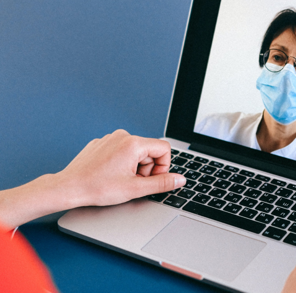 Woman using laptop to talk to mask wearing woman