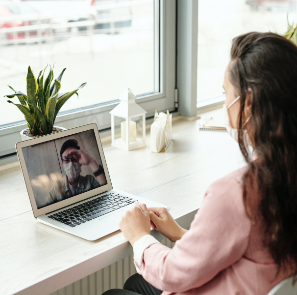 Woman talking to person on laptop
