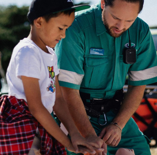 Paramedic and young boy practicing CPR
