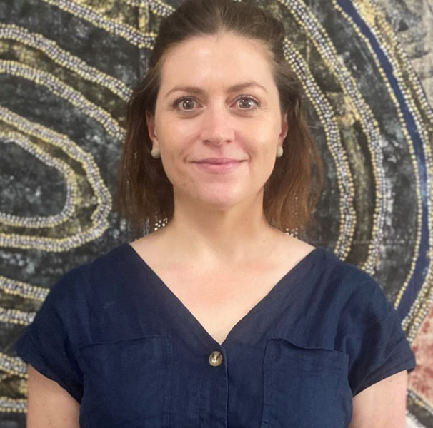 Sally West from James Cook University Centre for Rural & Remote Health, pictured in front of an artwork by The Women’s Engagement Group, Napranum.