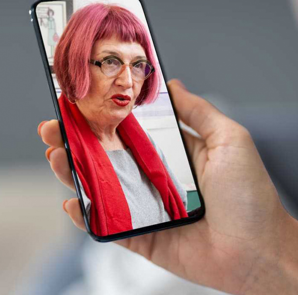 Woman holding phone video calling a woman with red hair.