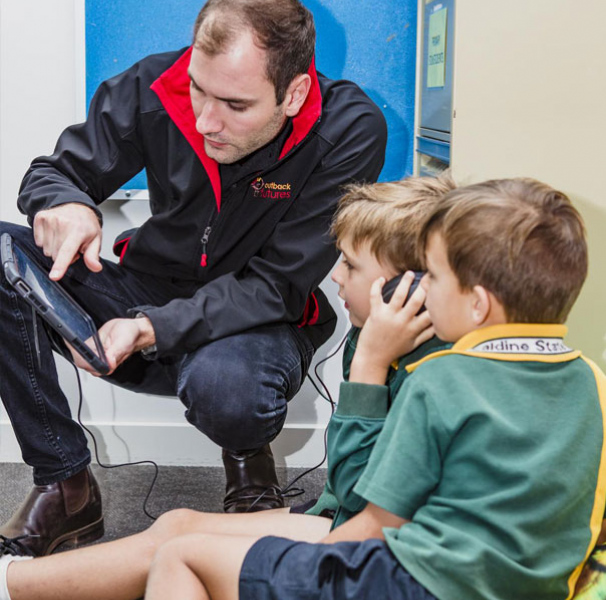 An Outback Futures staff member explaining the Rumble’s Quest tool to school children.