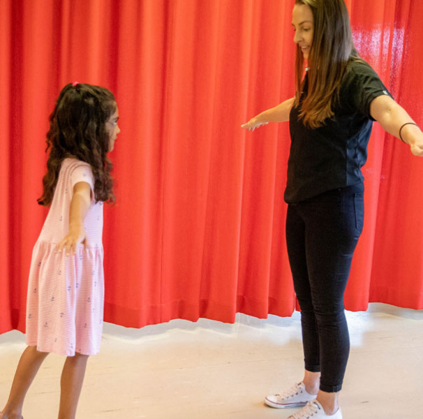 Woman with girl doing balancing exercises