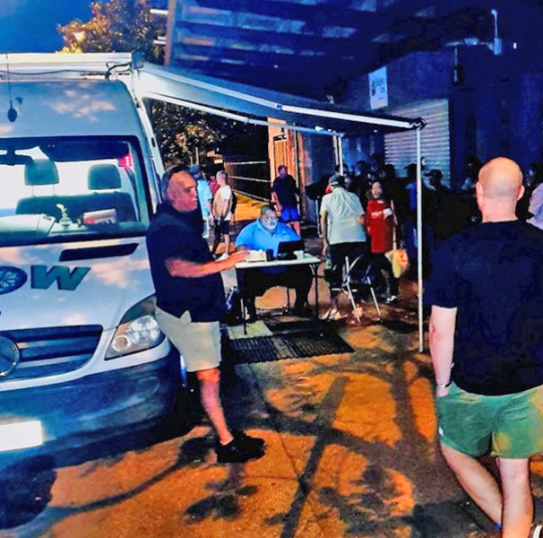 People outside of wheels of wellness van
