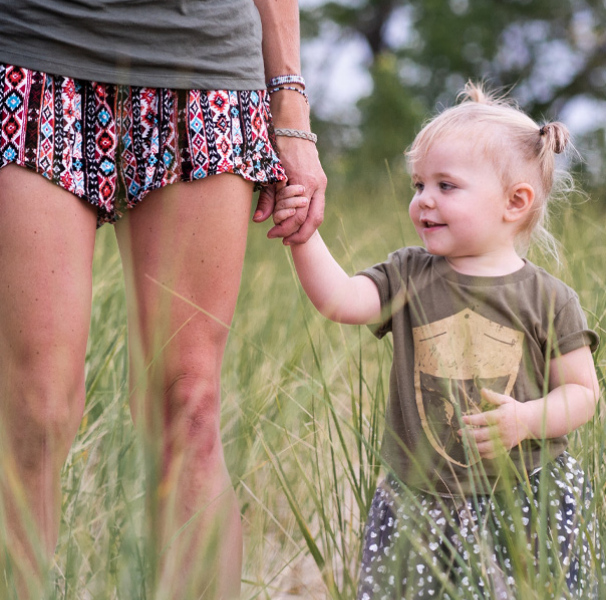 Mother with young toddler walking in the grass