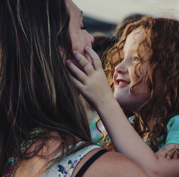 Mother holding smiling daughter
