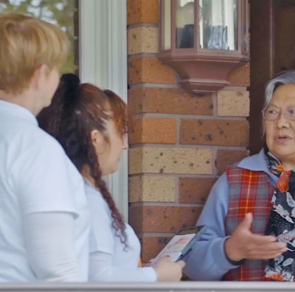 ACDC workers talking to person at their front door