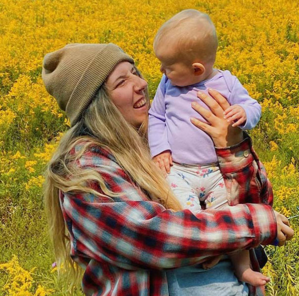 Woman in canola field with baby