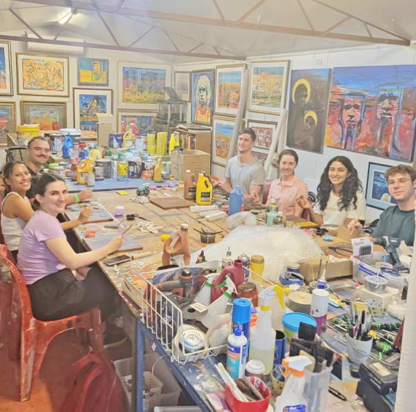 Some students seated at a table working on art projects