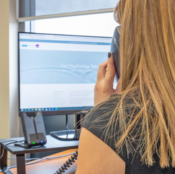 Woman using phone seated at an office desk