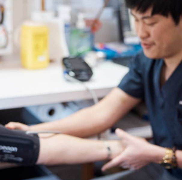 Nicholas Wong taking blood pressure measurement with female patient