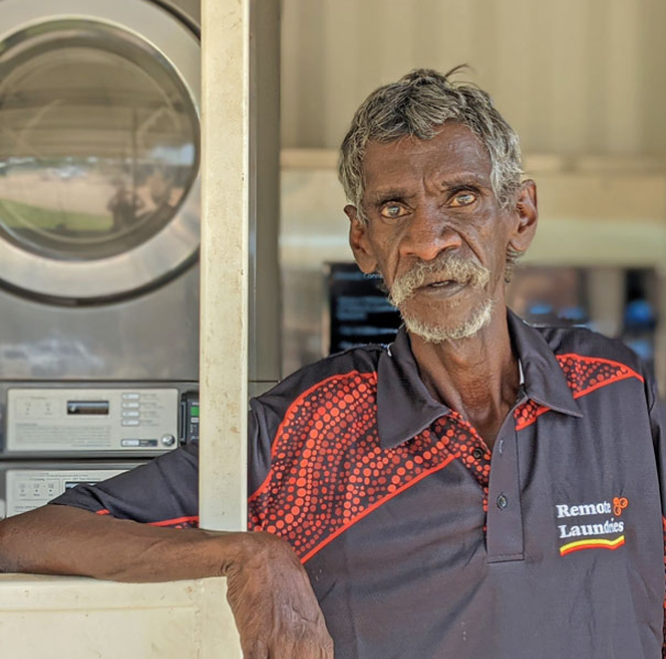 Frederick ‘Freddie’ Scrubby, who works at the Barunga laundry. Standing in front of laundry machines.